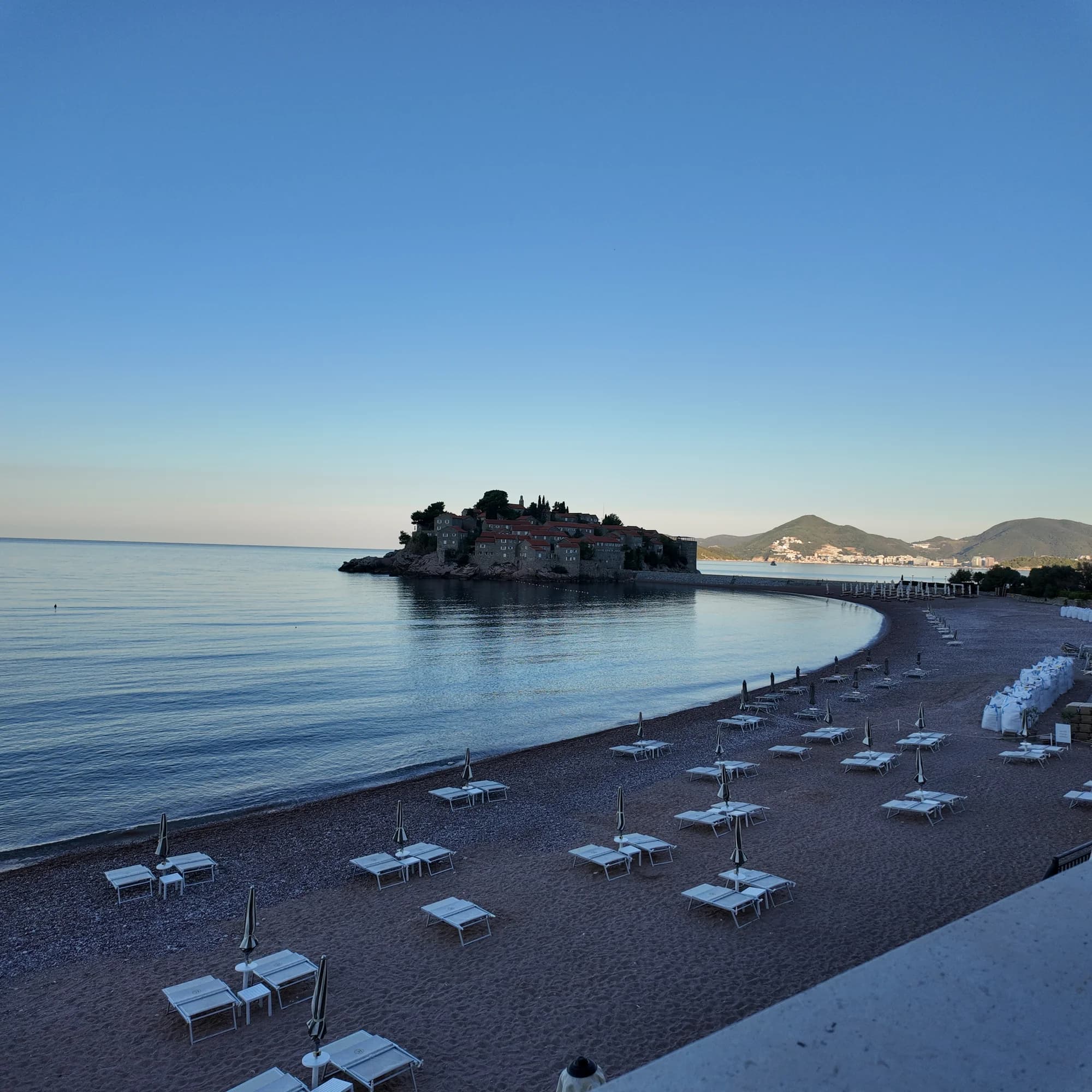 Sveti Stefan islet and the north beach in the still blue light before sunrise