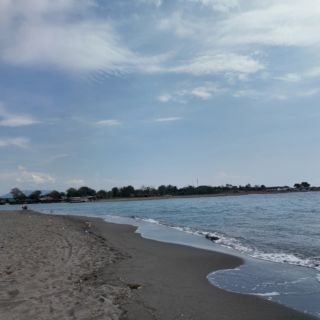 The grey sand of Ada Bojana curving away towards the mouth of the river, the sea grey-blue under September cloud
