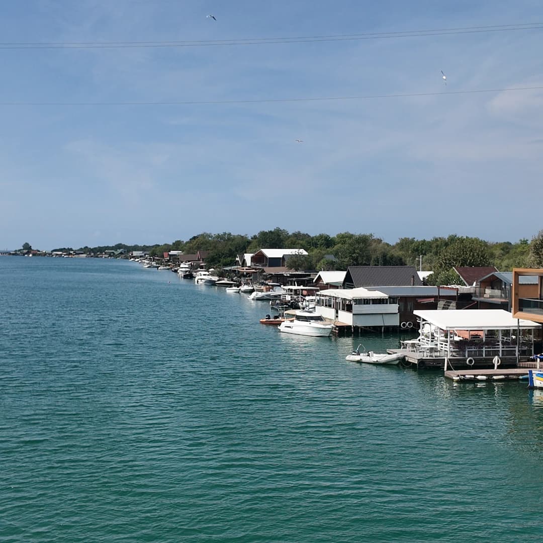 Restaurants on stilts along the Bojana river, boats moored beneath them