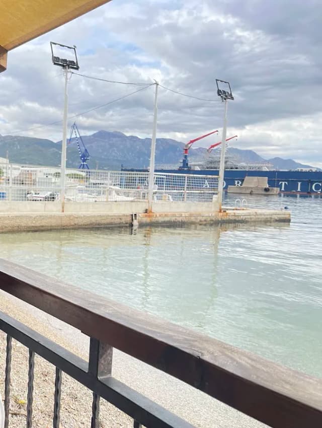 Dizalice brodogradilišta u Bijeloj viđene preko vode sa terase na obali