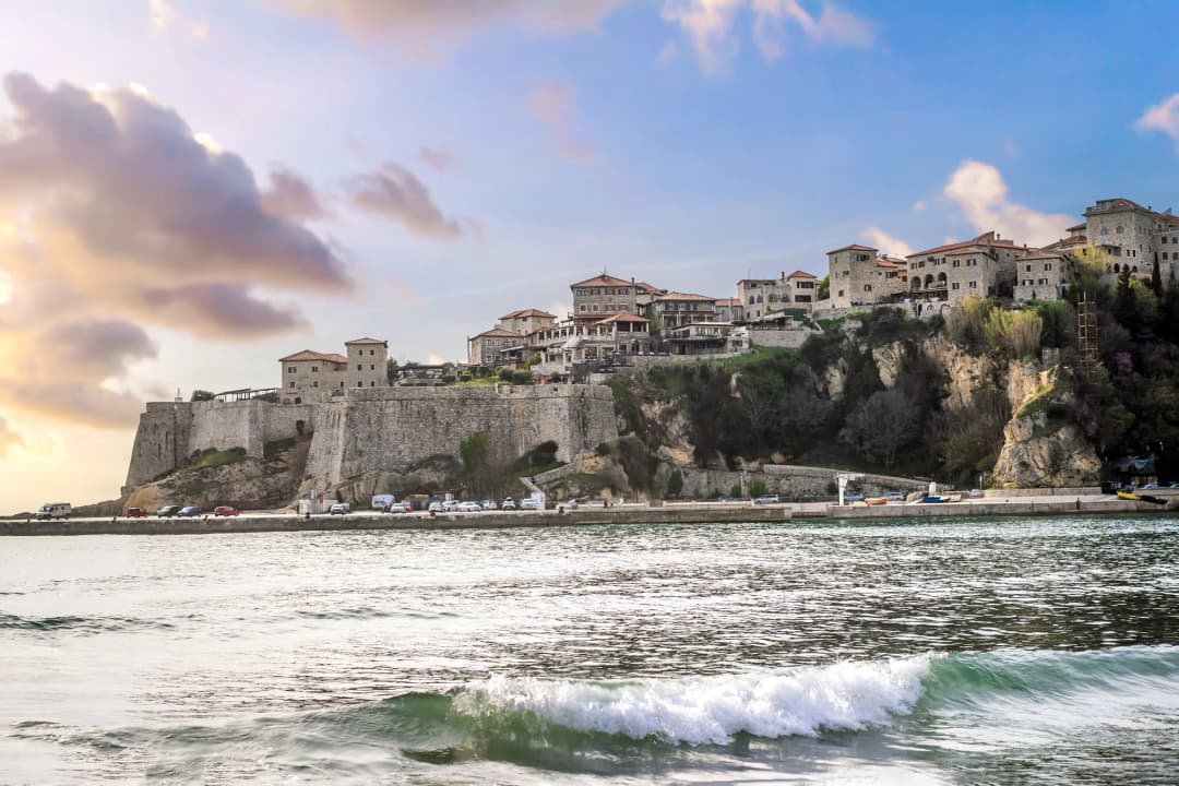 Ulcinj's walled old town on its rock at sunset, seen from the water