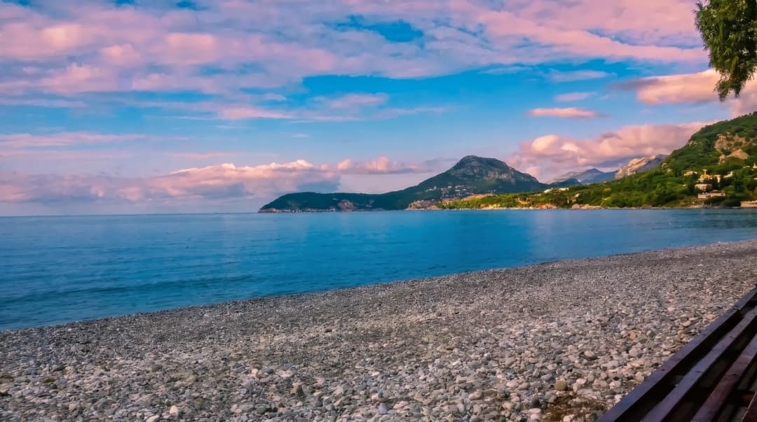 Žukotrlica beach near Bar, where pines come down to a pebble shore and clear shallow water.