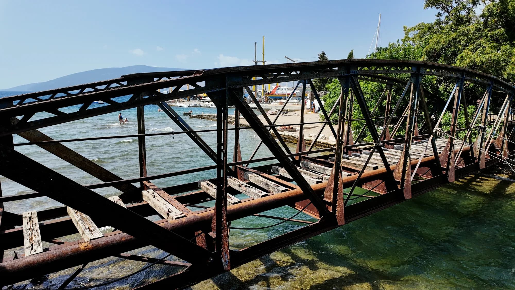 Die verrostete eiserne Eisenbahnbrücke am Ufer von Zelenika