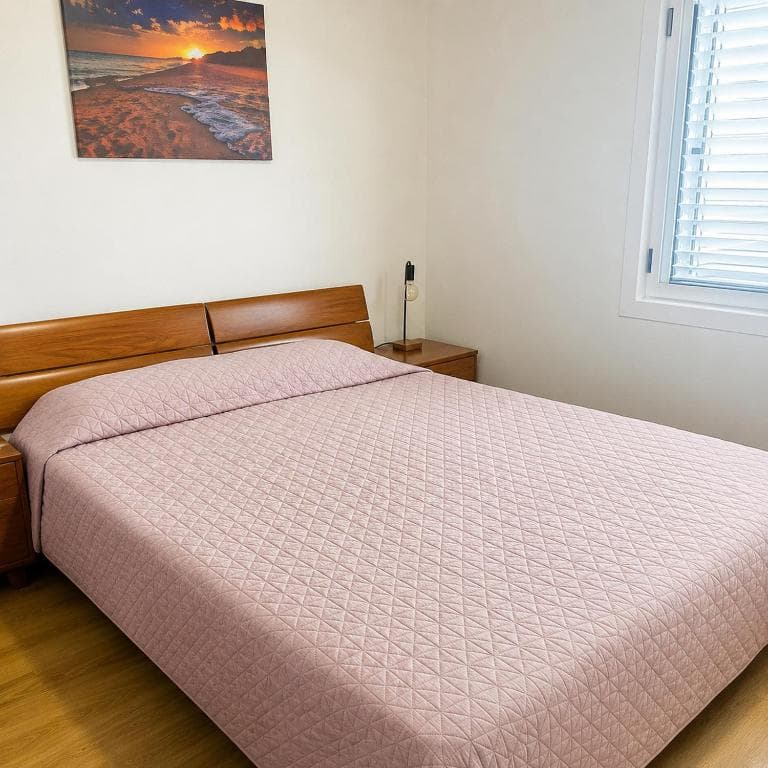 Double bedroom with wooden headboard at Lyon Apartmani Budva