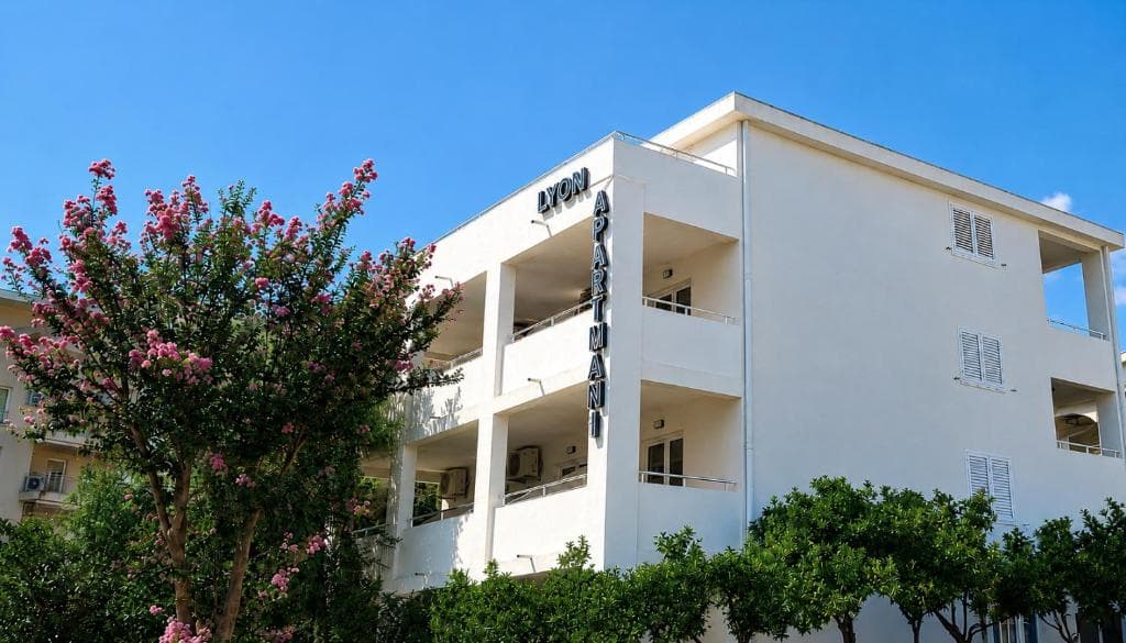 Lyon Apartmani building seen past a flowering crape myrtle, Budva