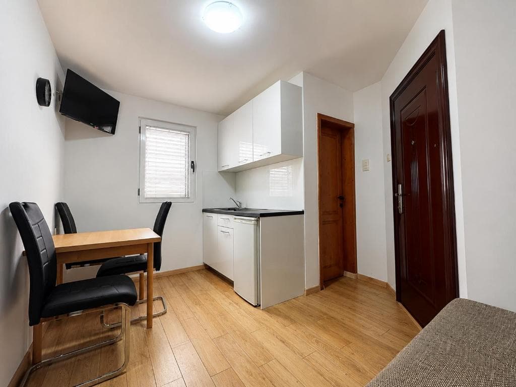 Dining table and kitchenette in a studio at Lyon Apartmani Budva