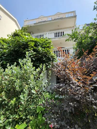 Villa Bozic — three tiers of white balustraded balconies above the summer garden