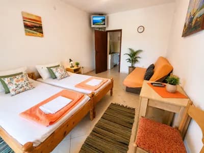 The studio room — twin beds, desk and kitchenette through the door