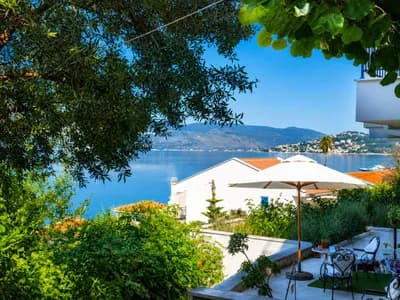 The villa terrace with its white umbrella above the rooftops and the bay