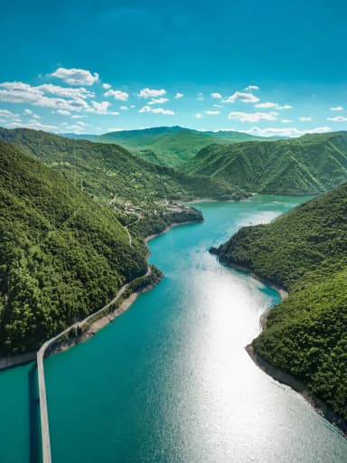 Blue Piva Lake winding between steep green canyon walls