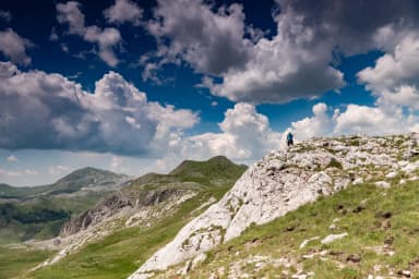 Hiker approaching a limestone summit in Durmitor