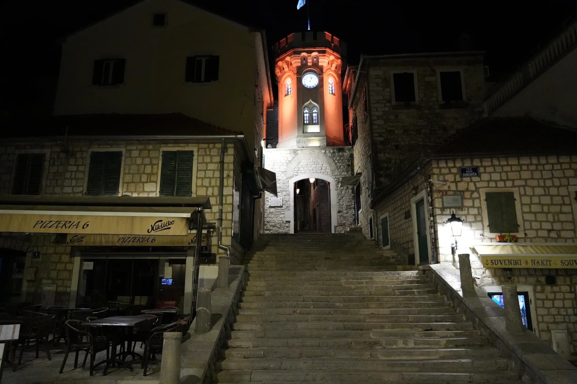 Escalones que conducen a la torre del reloj Sahat Kula iluminada al anochecer