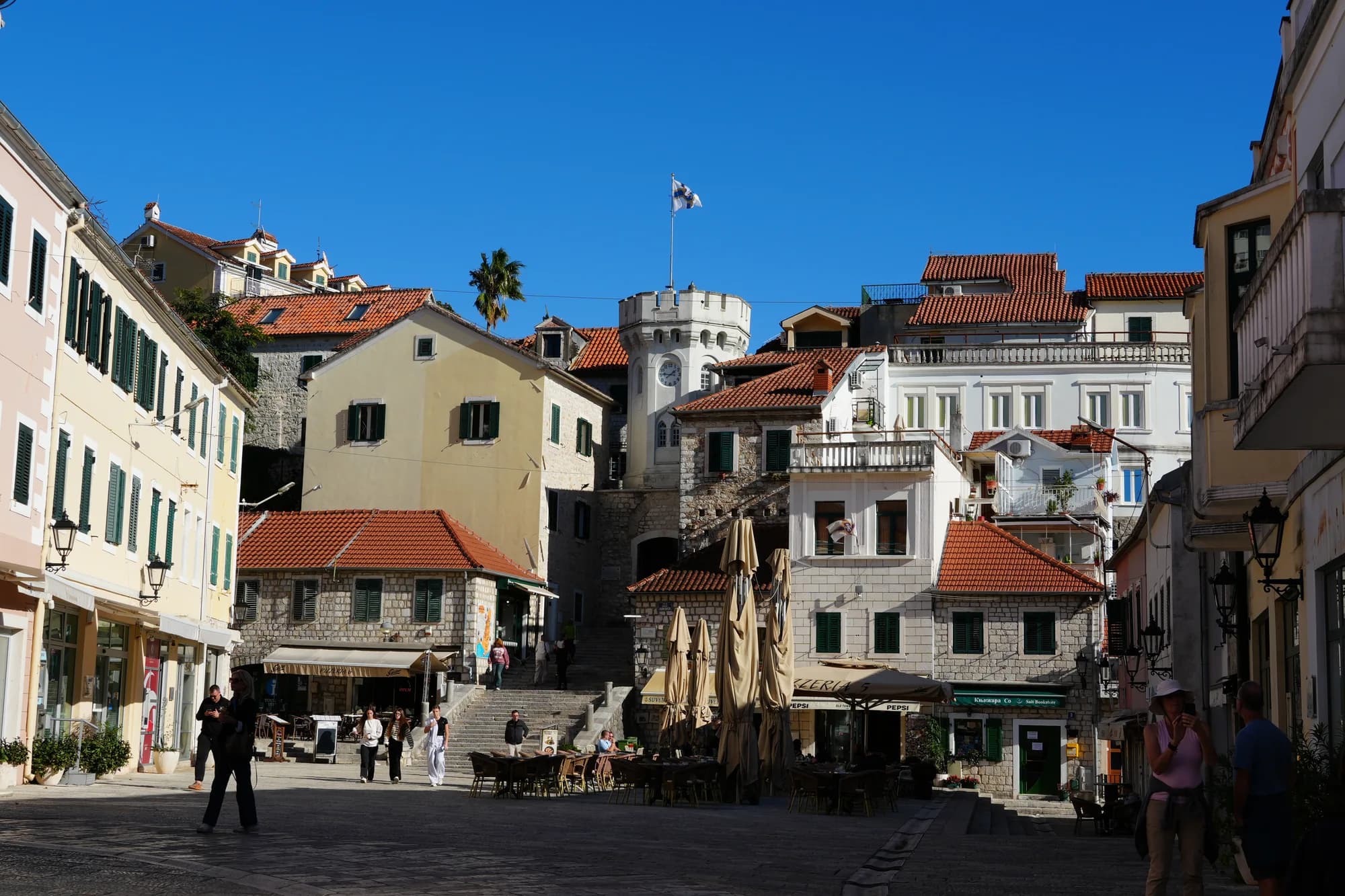 La plaza Nikola Đurković con la torre del reloj Sahat Kula sobre las terrazas de los cafés