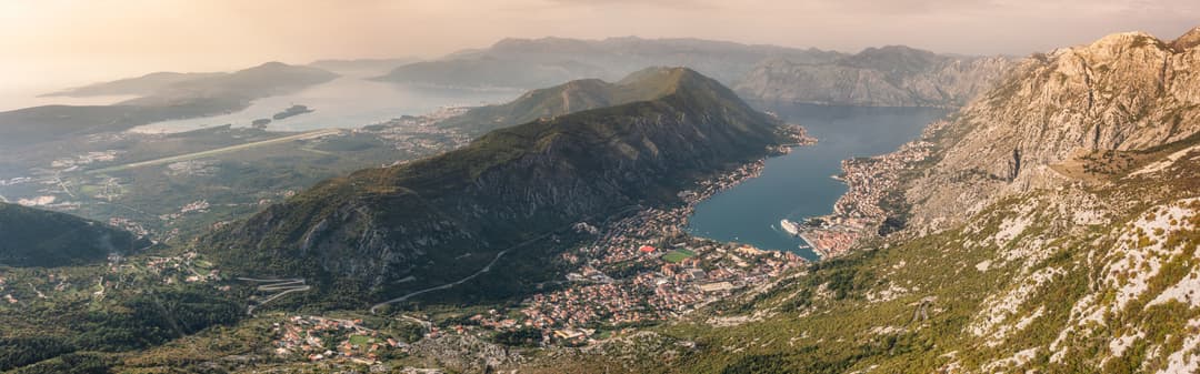 Vista aérea panorámica de la Bahía de Kotor con montañas descendiendo hacia la bahía de tipo fiordo