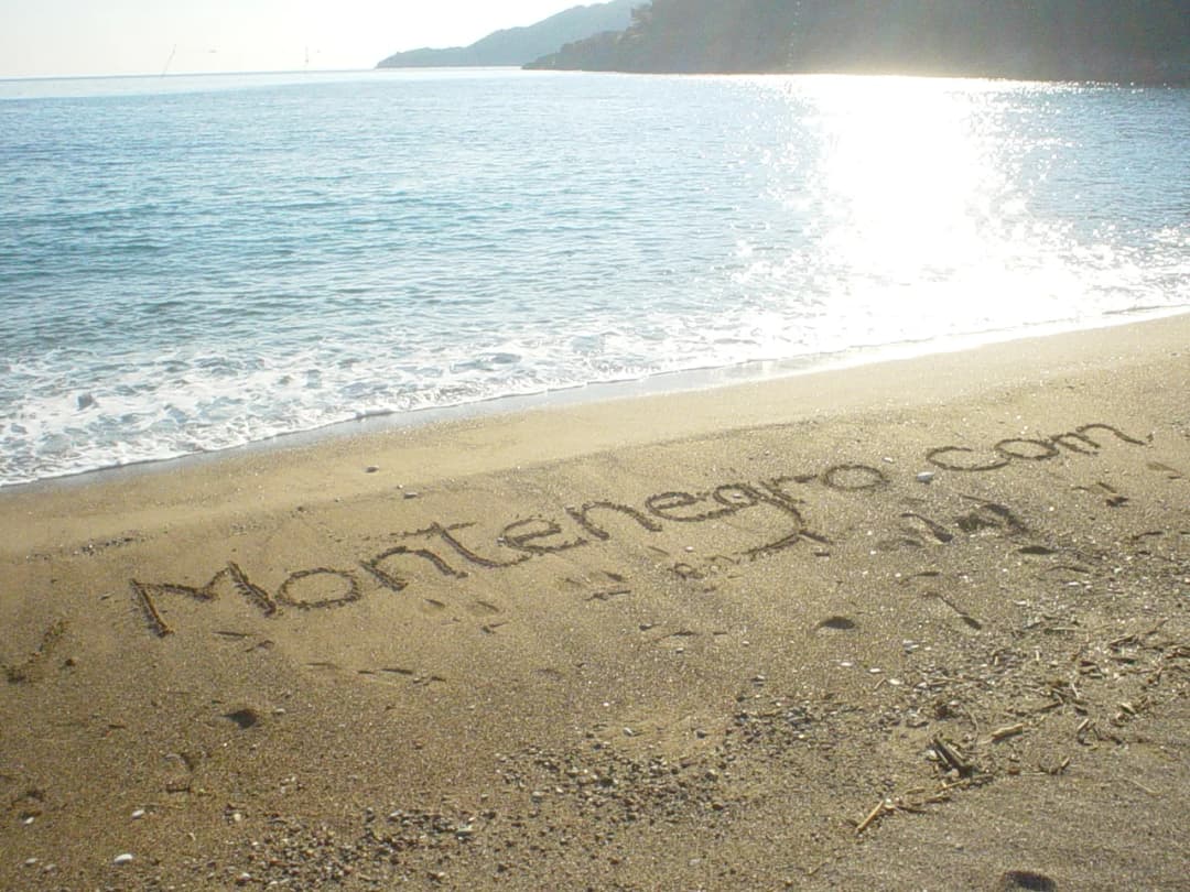 Montenegro.com written in sand at the waterline