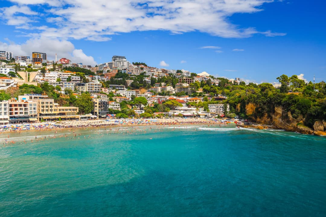 Mirna plaža u blizini Utjehe ili Dobre Vode s bistrom jadranskom vodom, planinama u pozadini i malo ljudi