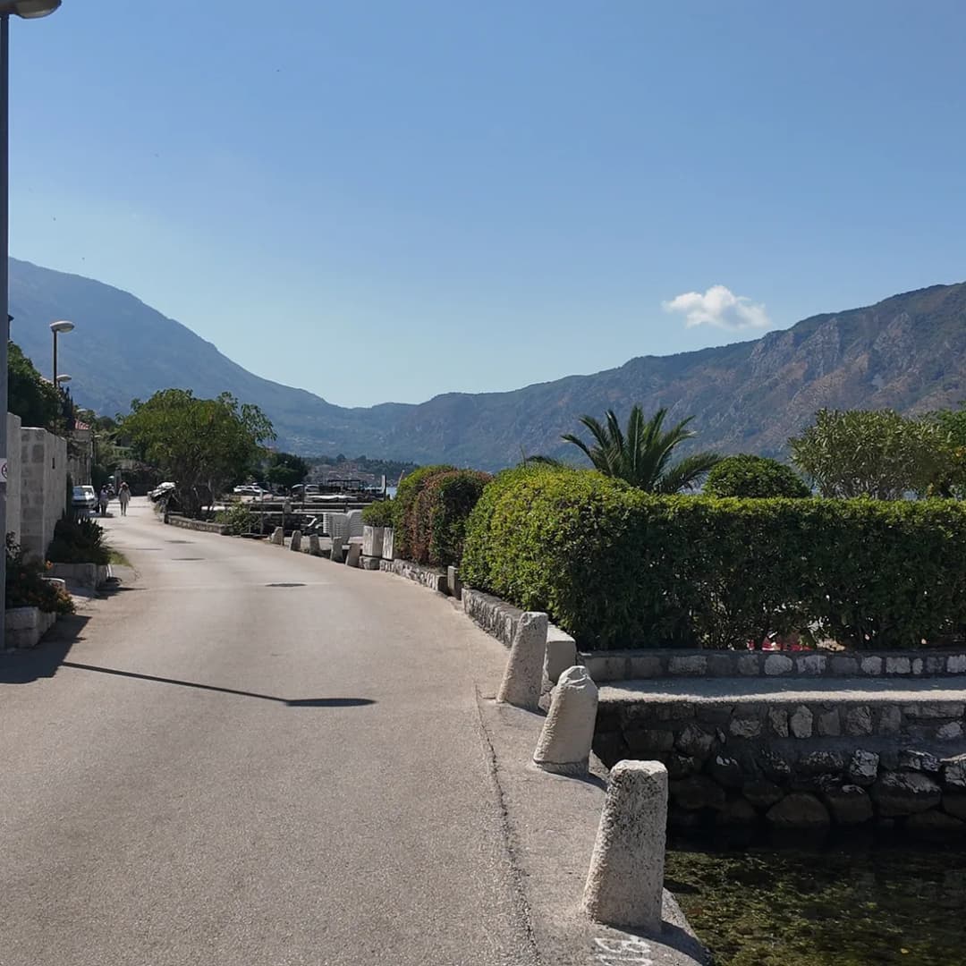 The narrow coastal road through Dobrota, hugging the waterfront along the Bay of Kotor.