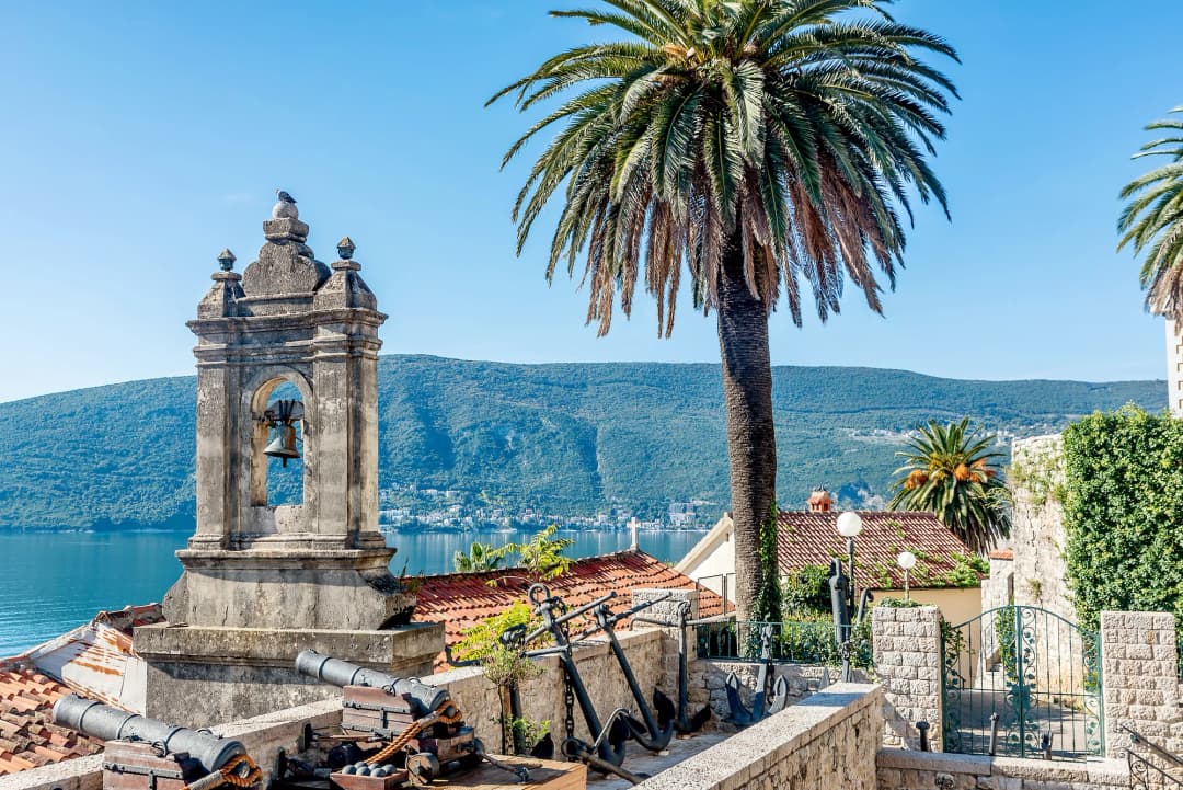 Vista de la Bahía de Kotor desde la carretera entre Herceg Novi y Kotor, mostrando la bahía parecida a un fiordo con montañas que se desploman en agua azul tranquila