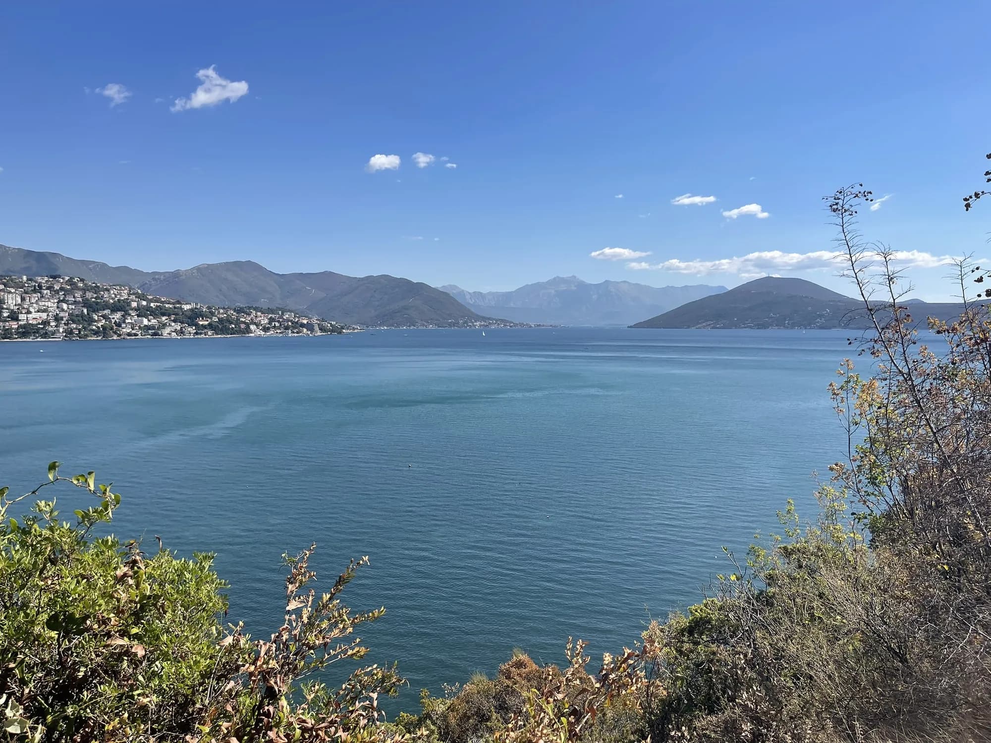 The open bay from the Njivice shore, Herceg Novi and Igalo strung along the far side under the Orjen massif