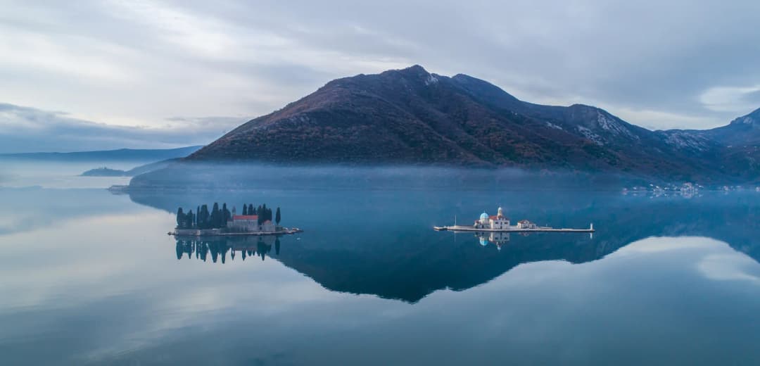 Magliasta zora preko Gospe od Škrpjela i otoka Svetog Đorđa blizu Perasta