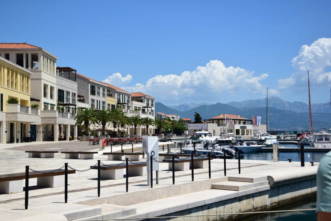 The Portonovi marina at Kumbor, with yachts moored along the quay and the waterfront buildings and hills of the bay behind them.