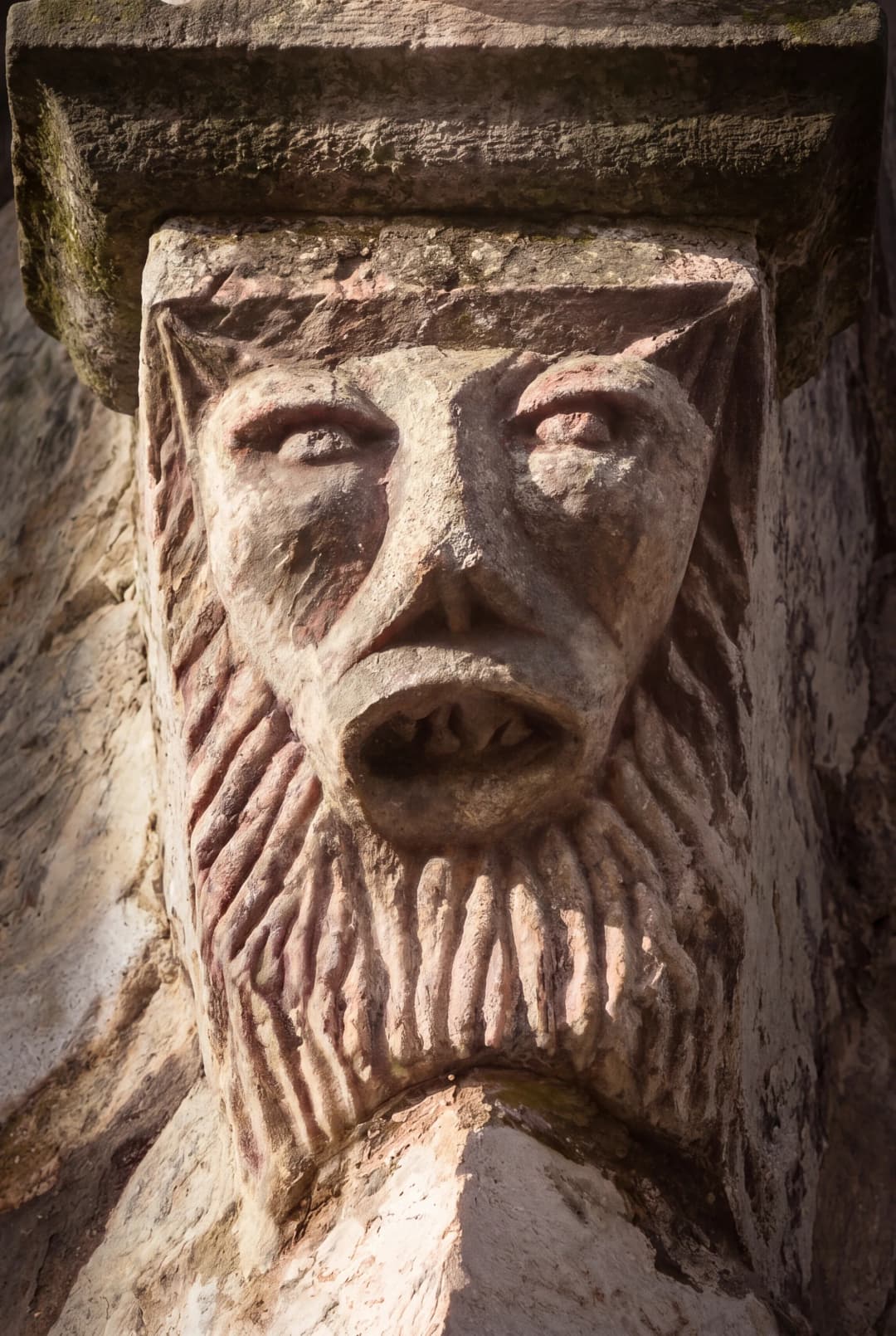 Carved stone face with a braided beard on the masonry of the Buća-Luković complex in Tivat