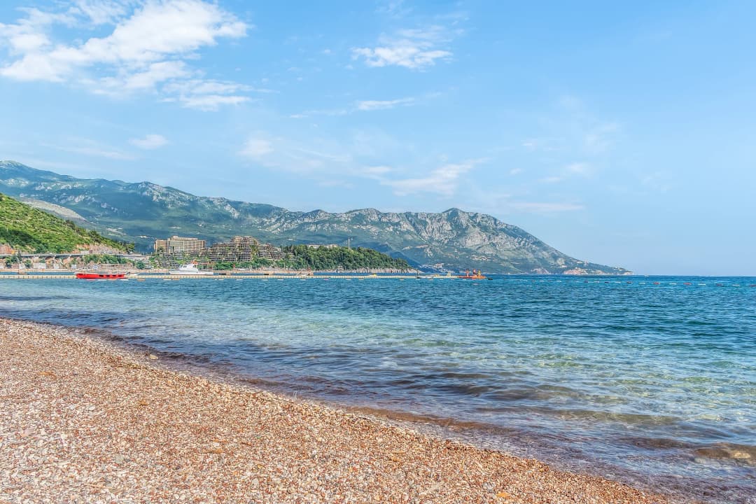 Šljunak Slovenske plaže sa budvanskim Starim gradom u daljini