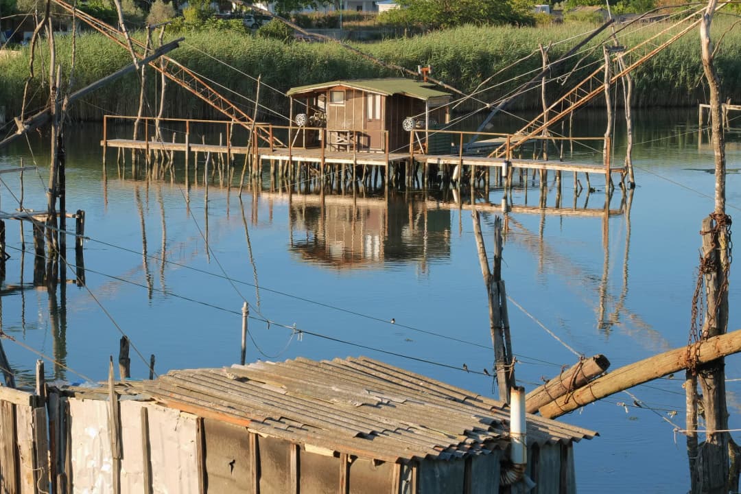 A weathered kalimera hut and walkway on Port Milena in golden evening light
