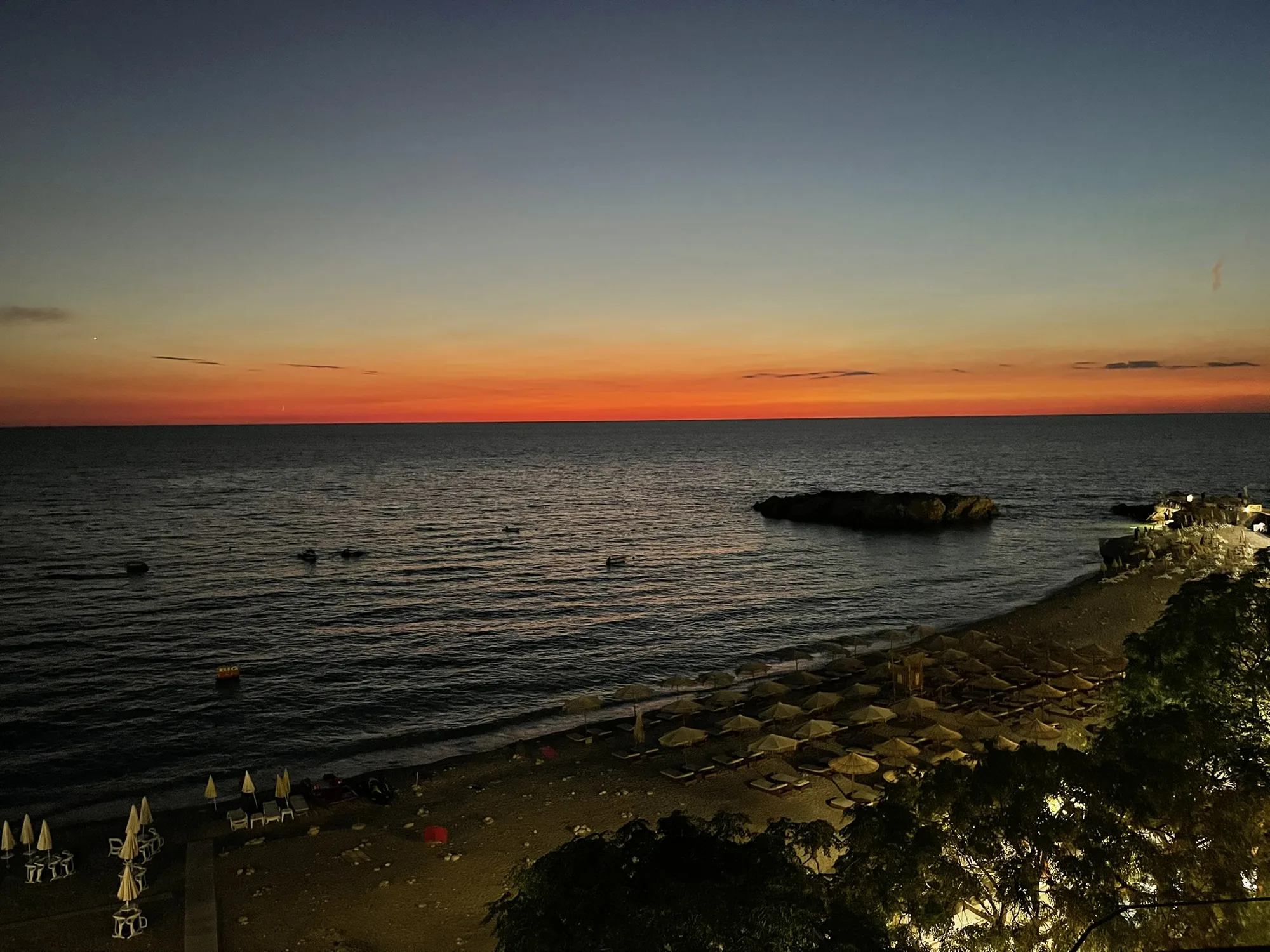 Orange afterglow over the sea at Veliki Pijesak, the islet dark against the water