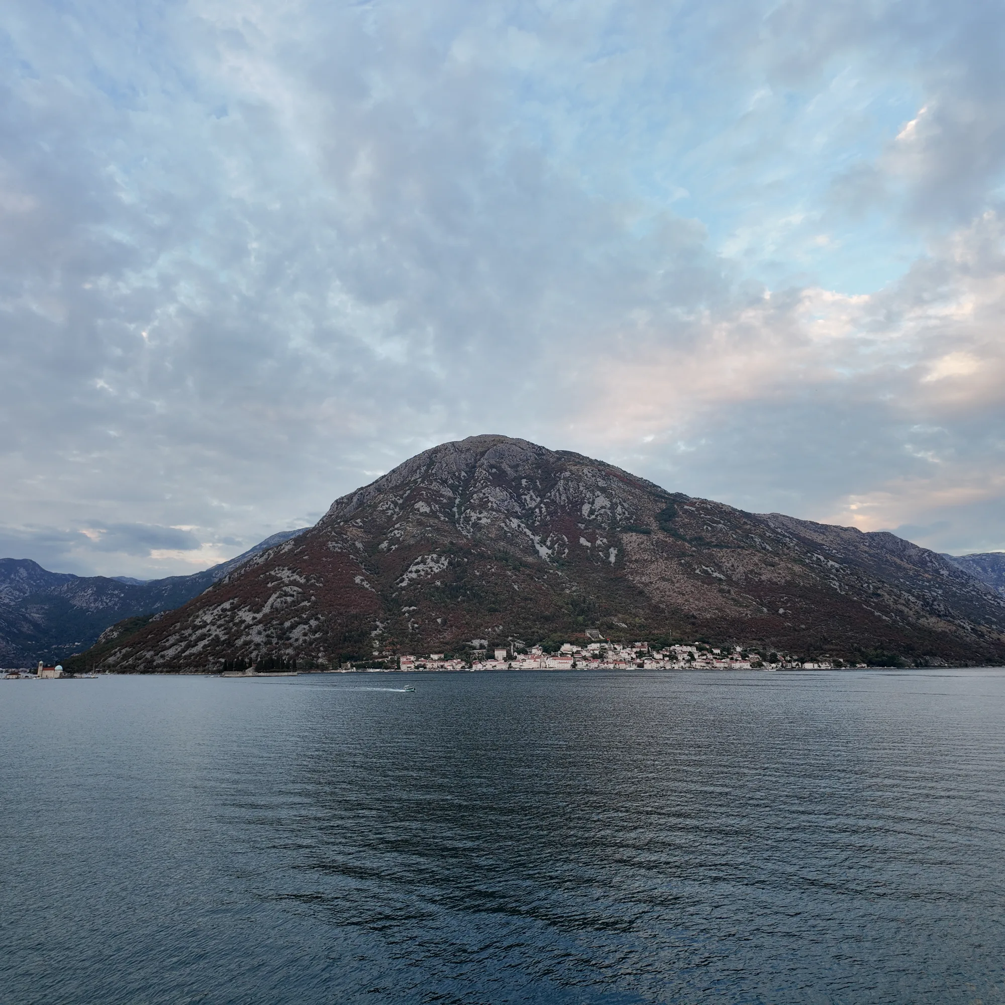 Evening sky over Perast and its mountain, the strait calm below