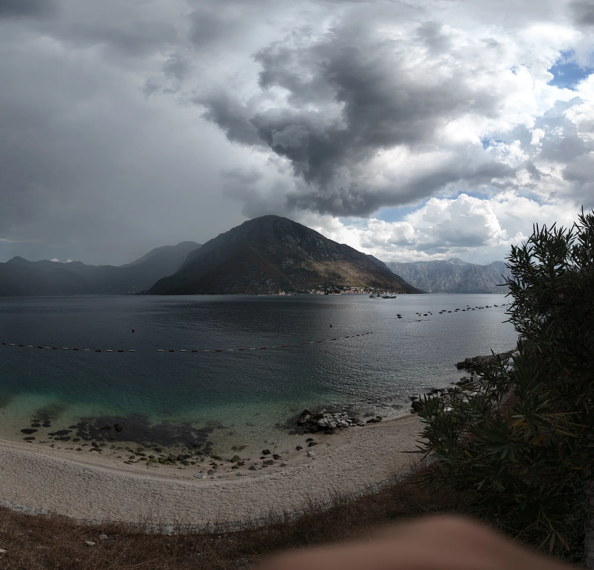 The shingle beach at Kostanjica under the storm, mussel-farm buoys in the strait