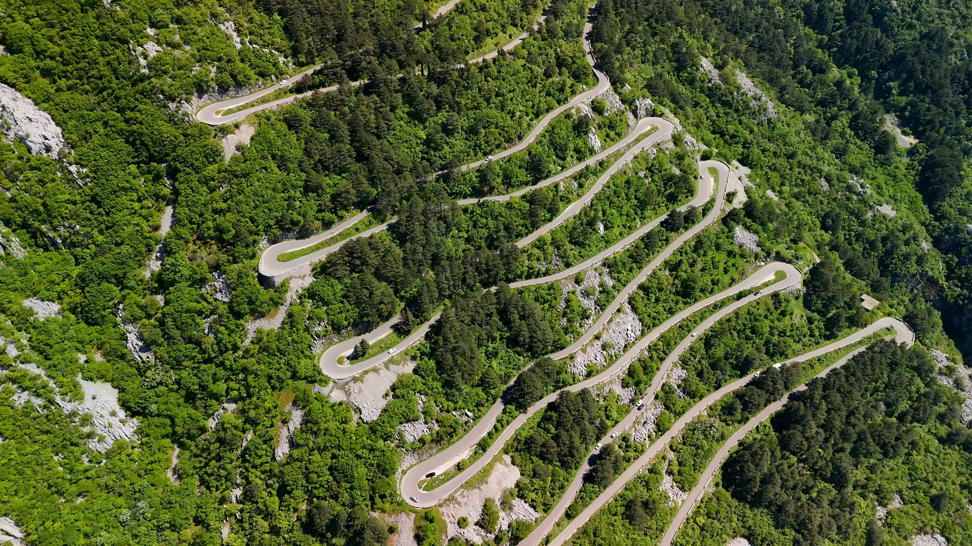 The looping switchback road climbing the bare slopes of Lovcen towards the summit, seen from above.
