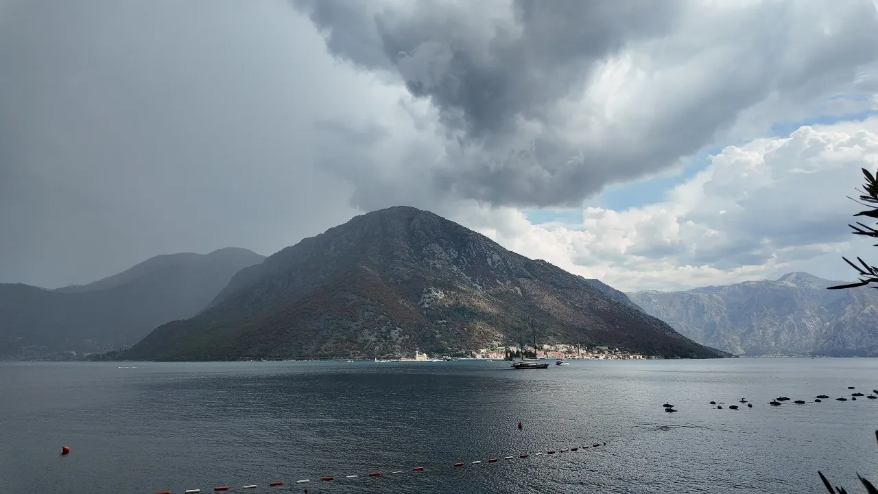 Una nube de tormenta creciendo sobre la montaña tras Perast, con el islote de Sveti Đorđe debajo, vistos al otro lado del estrecho desde Kostanjica