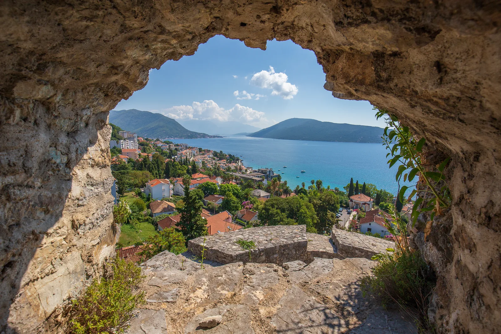 The Bay of Kotor and a waterside town framed through a rock window