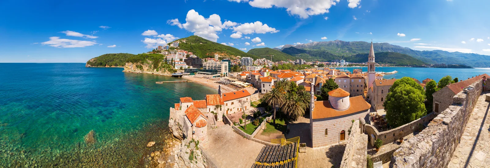 Panorama sobre los tejados de la Ciudad Vieja de Budva, ciudadela y mar turquesa desde las murallas de la ciudad