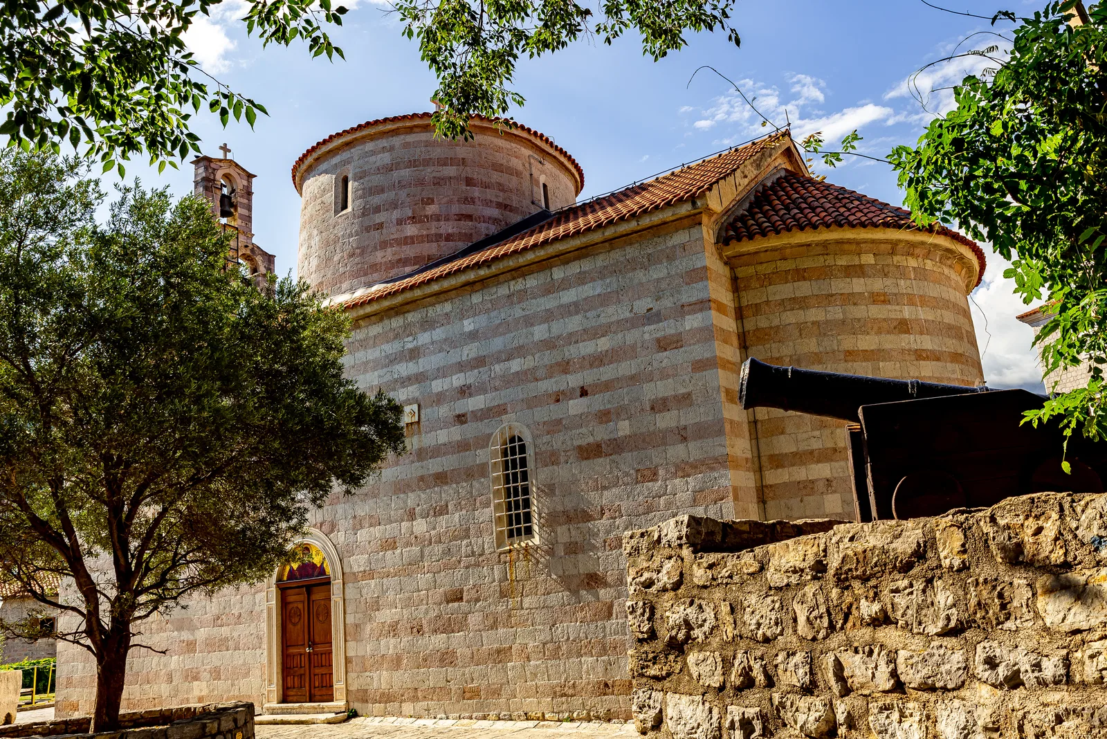 The old stone Santa Maria in Punta church with a cannon in Budva Old Town