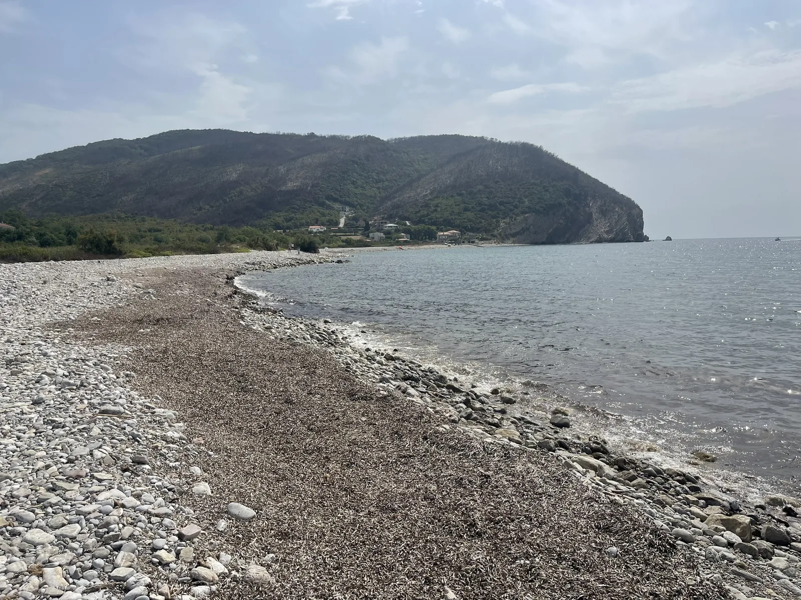 The pebble beach at Buljarica curving away below the headland