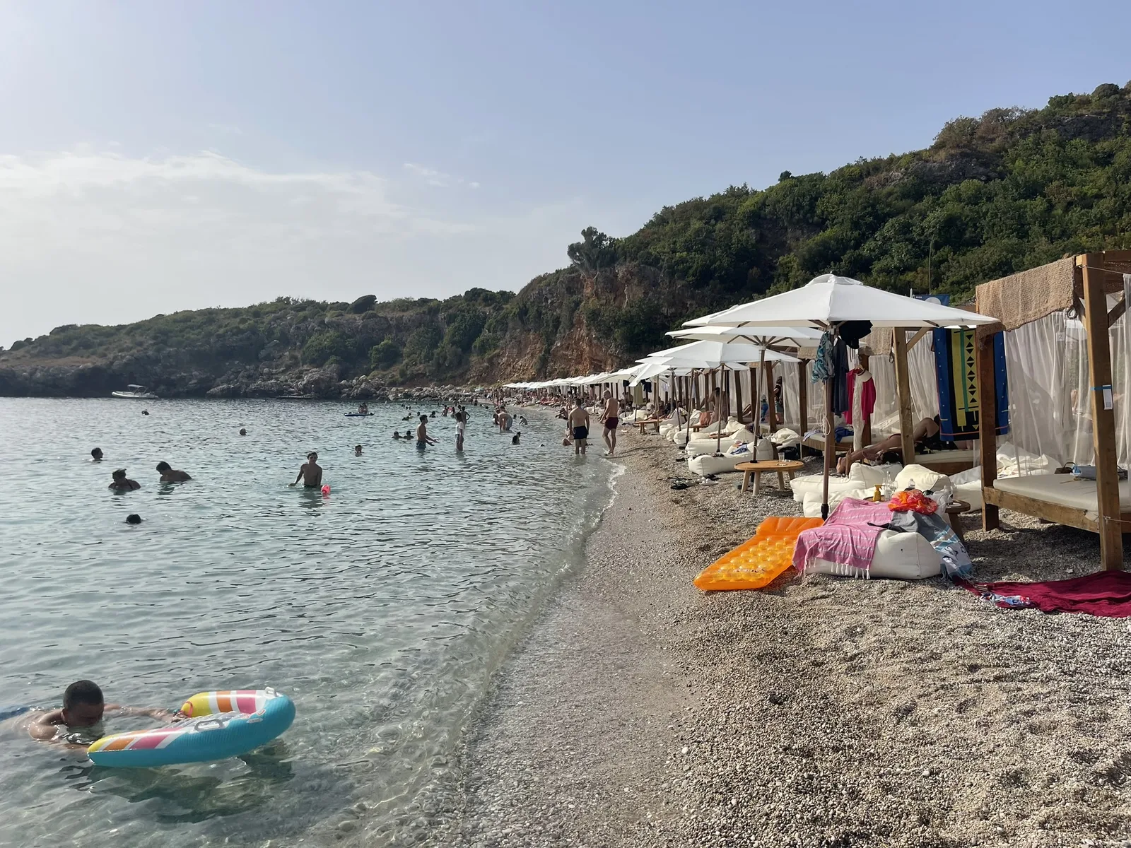 The pebble beach at Drobni Pijesak seen from the shore, boats drawn up at the water