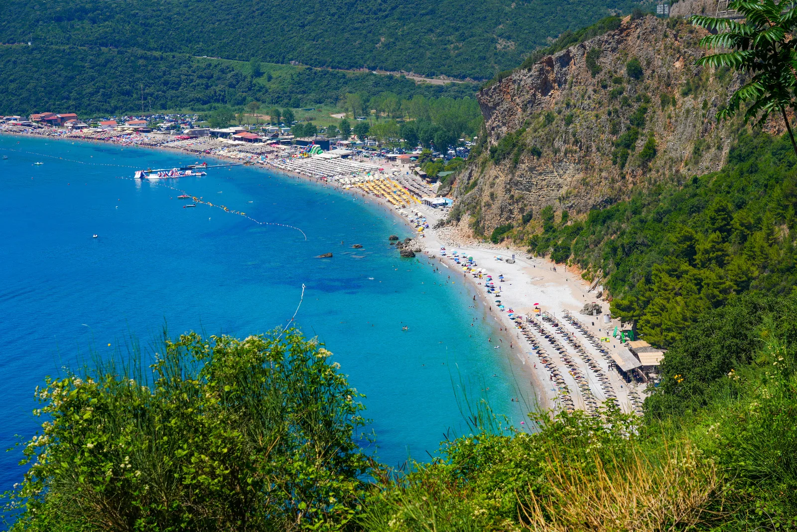 Jaz Beach and its turquoise cove seen from the green headland above