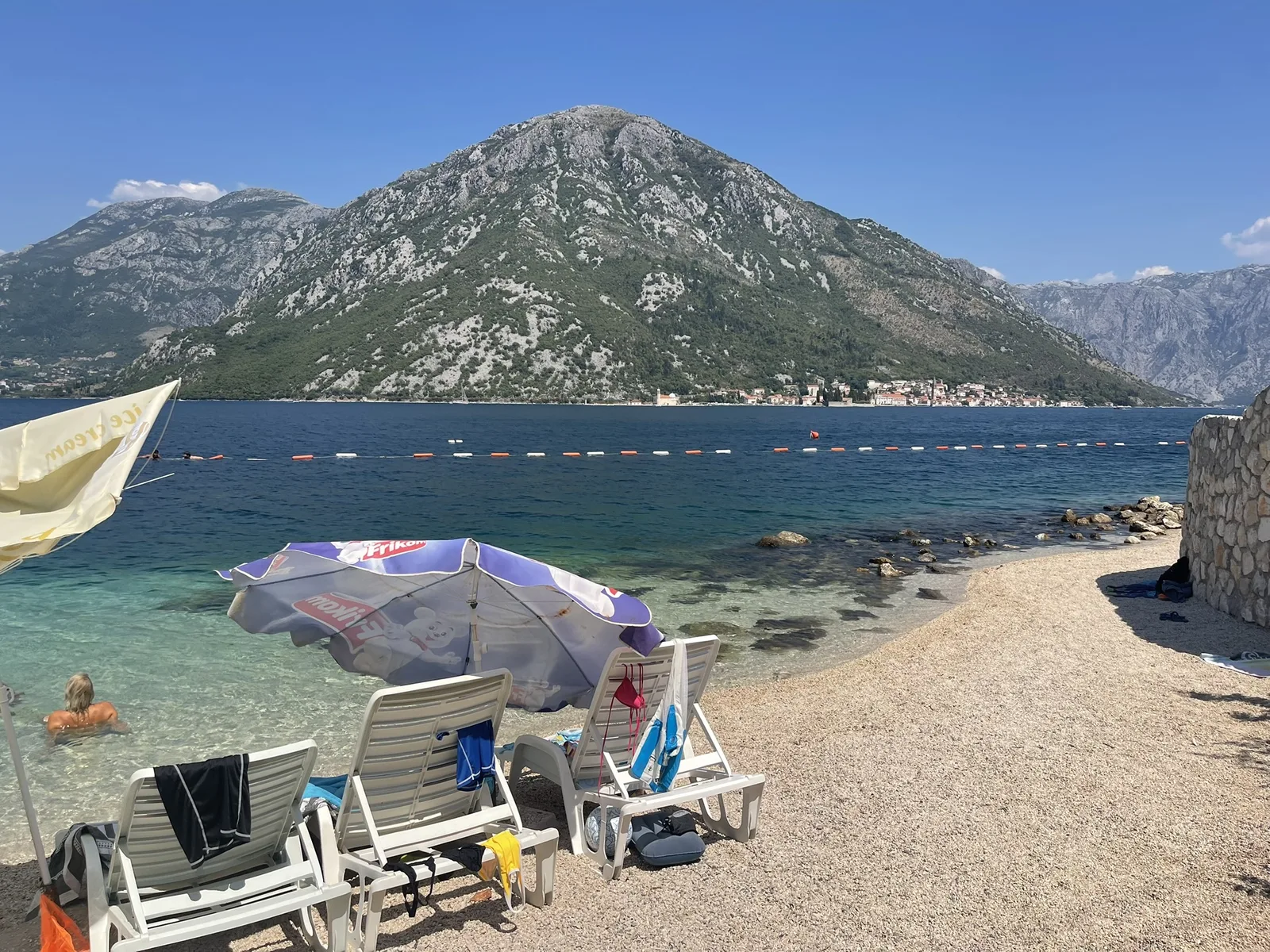 The small beach at Kostanjica with parasols and clear water