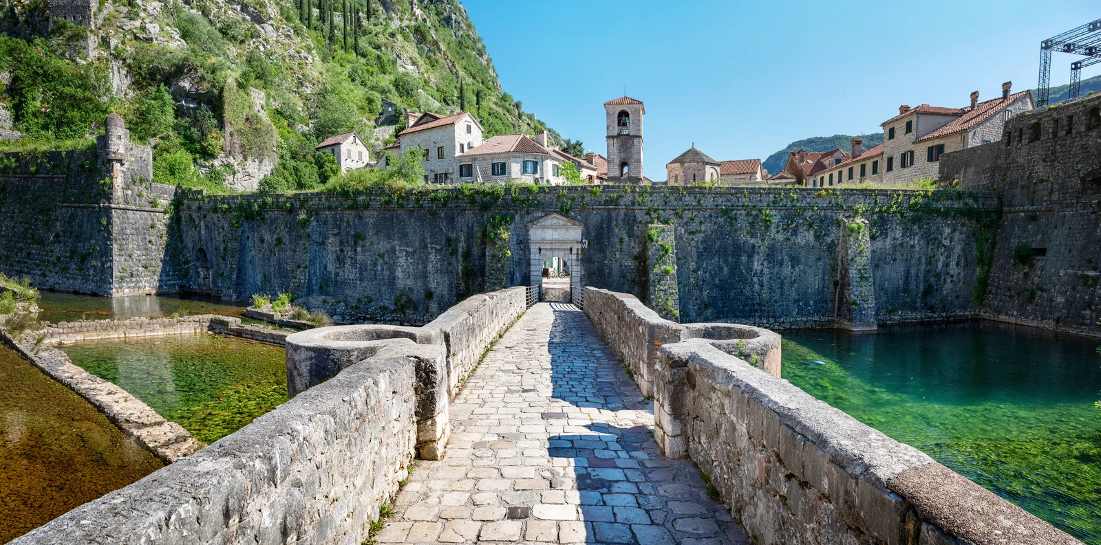 Puente de piedra cruzando el foso hacia la Puerta del Río de las murallas del Casco Antiguo de Kotor