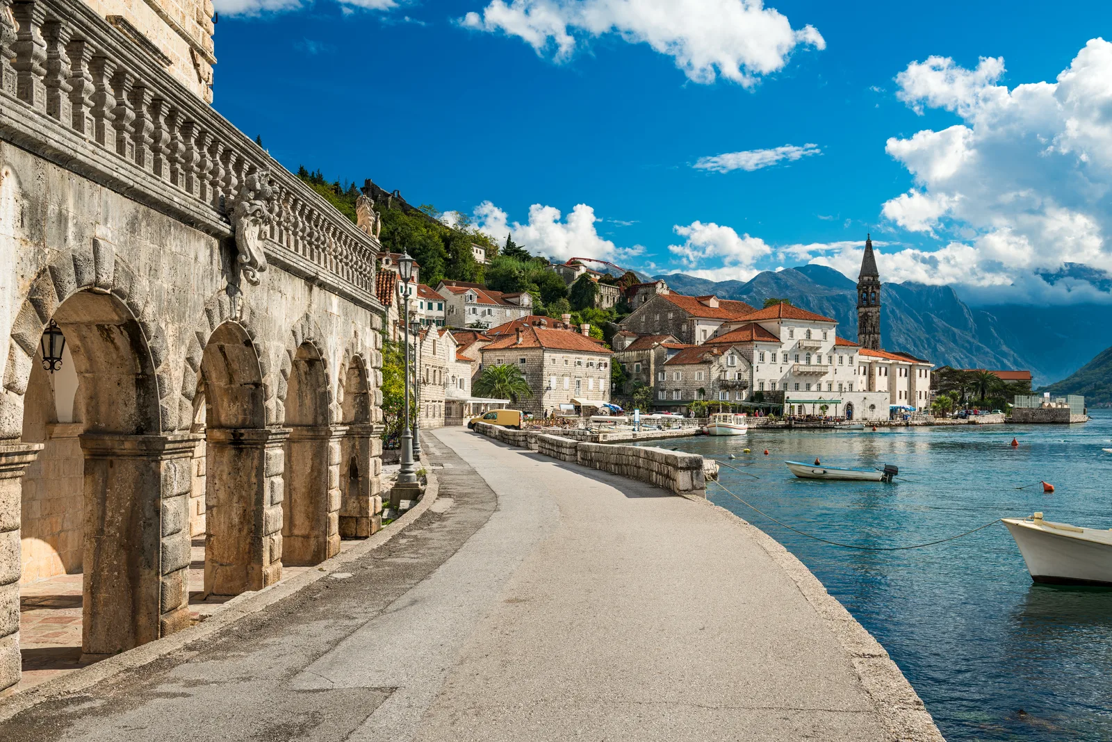 El palazzo de piedra con arcadas y el paseo marítimo de Perast, con su alto campanario y la bahía