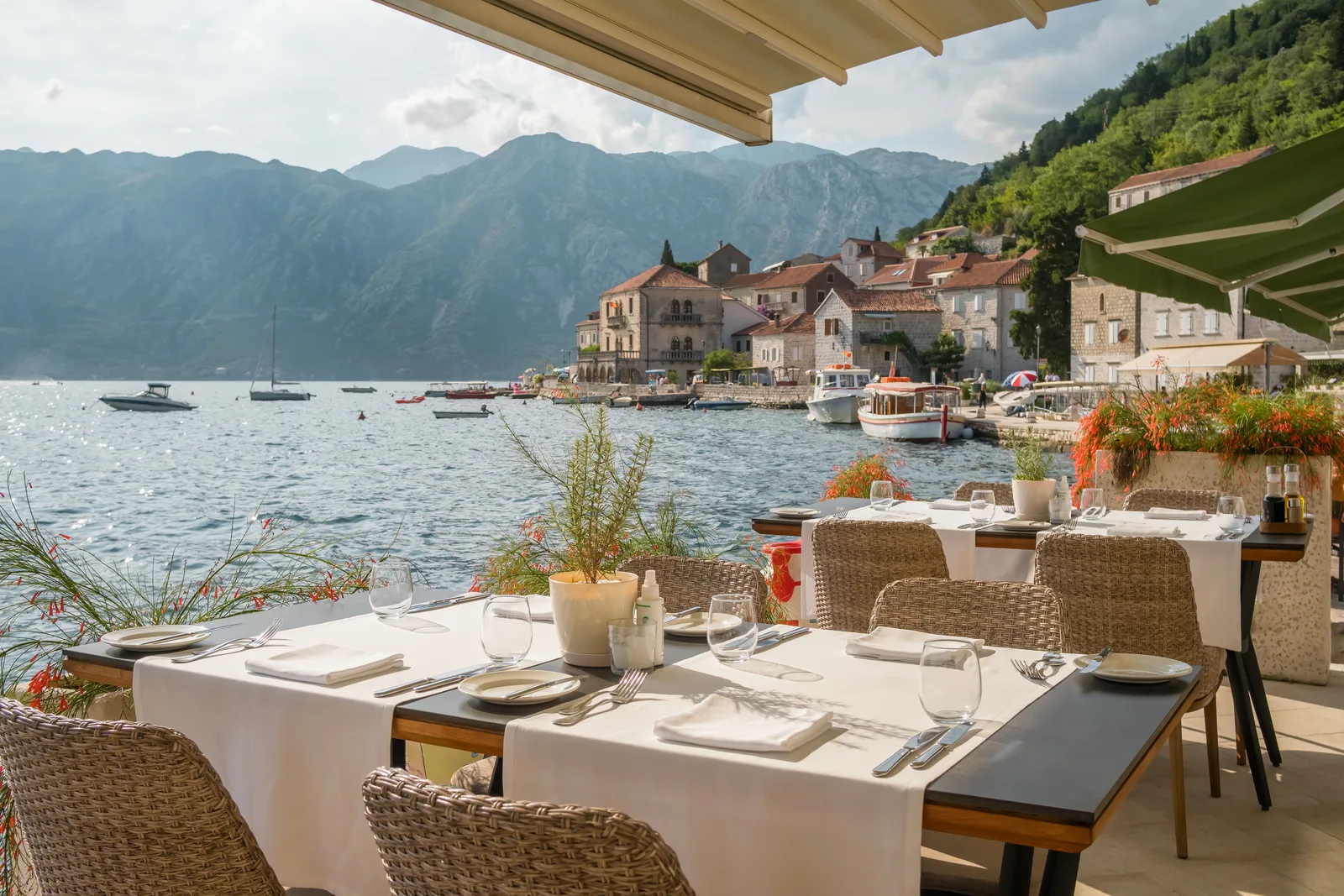 Una mesa de restaurante en la orilla del agua con vistas sobre Perast y la Bahía de Kotor