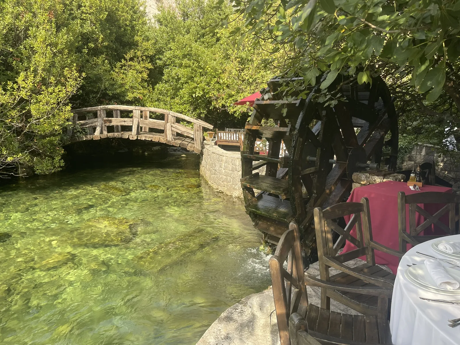 A wooden waterwheel beside a stone bridge over the mill race at Stari Mlini