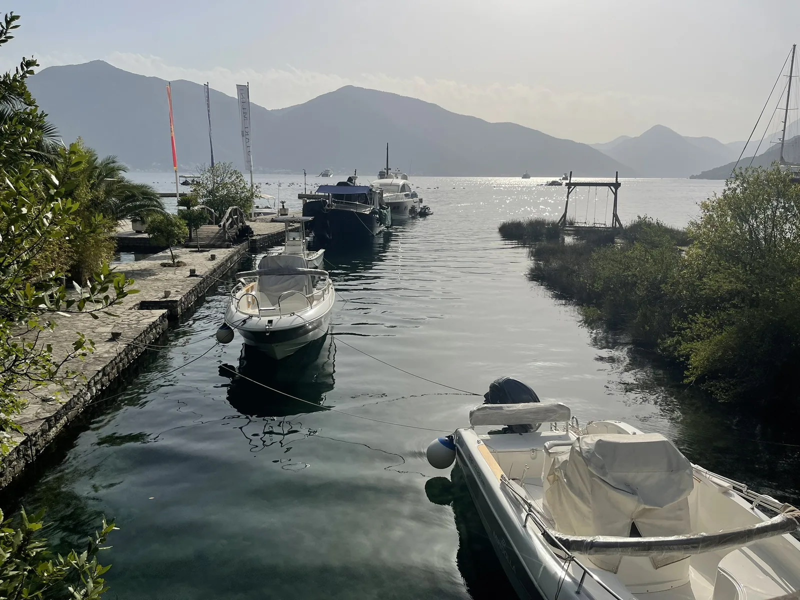 The restaurant jetty at Stari Mlini with small boats moored on the Bay of Kotor