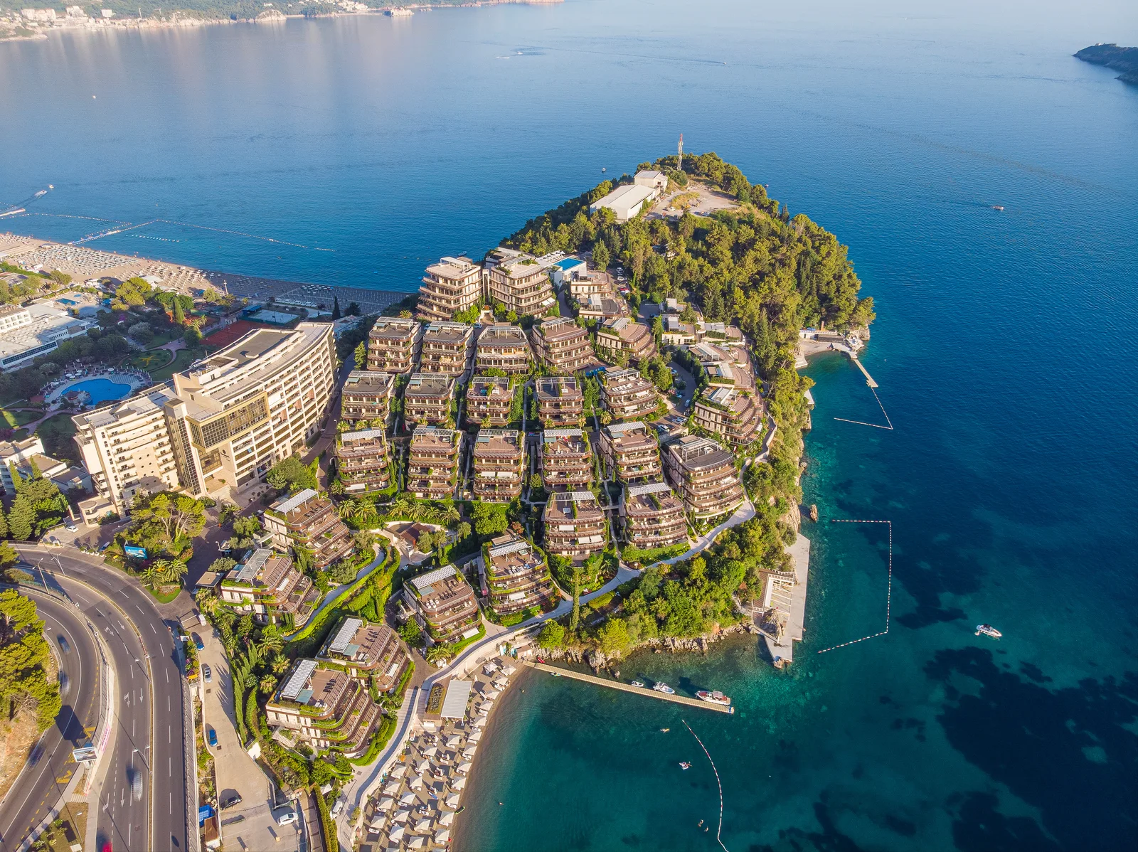 Vista aérea de las residencias escalonadas de Dukley Gardens en la península de Becici por encima de la playa