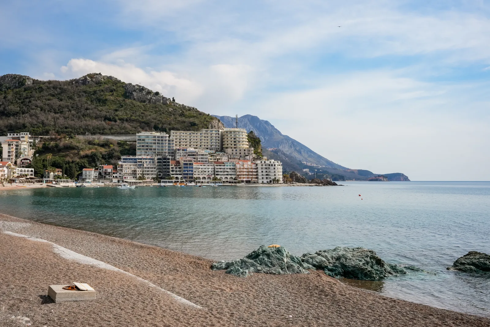 Hoteles apilados en la ladera por encima de la playa en Rafailovici, junto a Becici