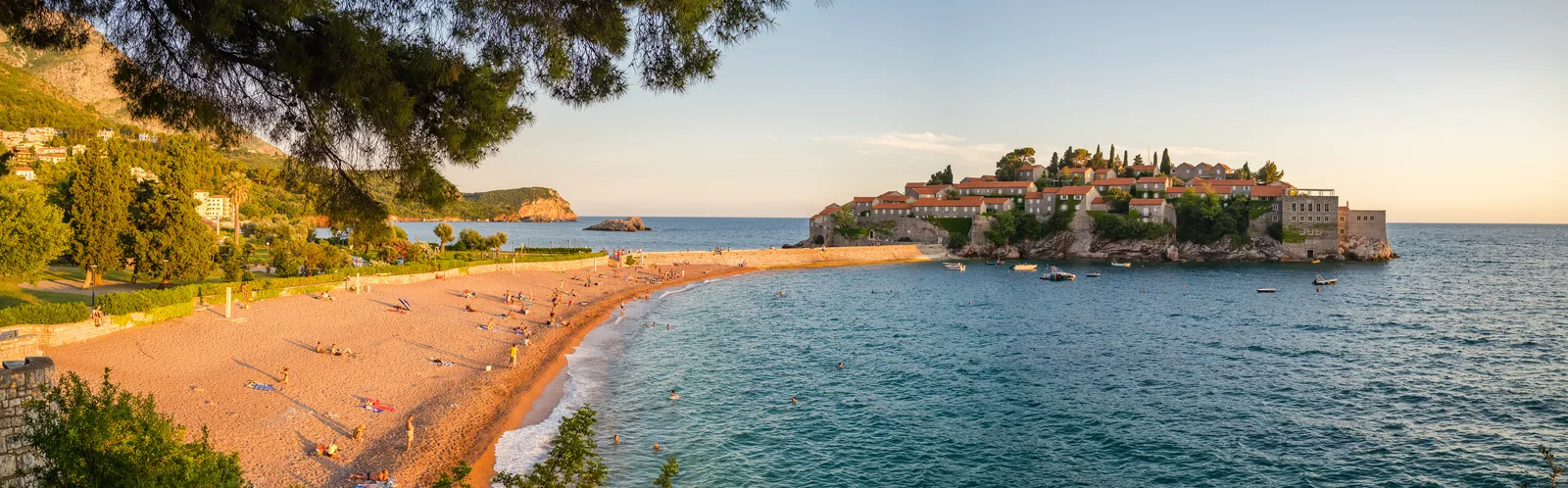 Aerial of Sveti Stefan island, its sandy isthmus and the Milocer beach and park behind