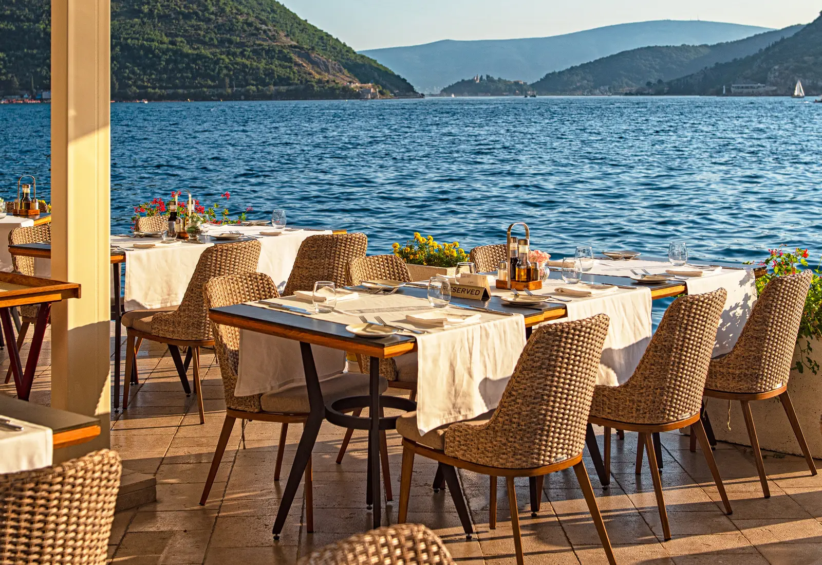 Waterfront restaurant tables set for dinner on the Bay of Kotor, Montenegro