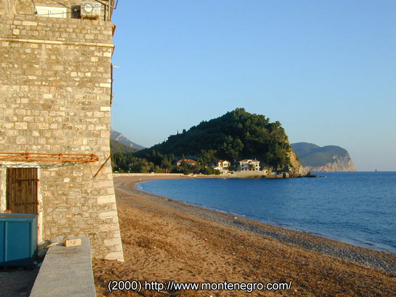 View along the Petrovac seafront promenade lined with palms and traditional stone buildings